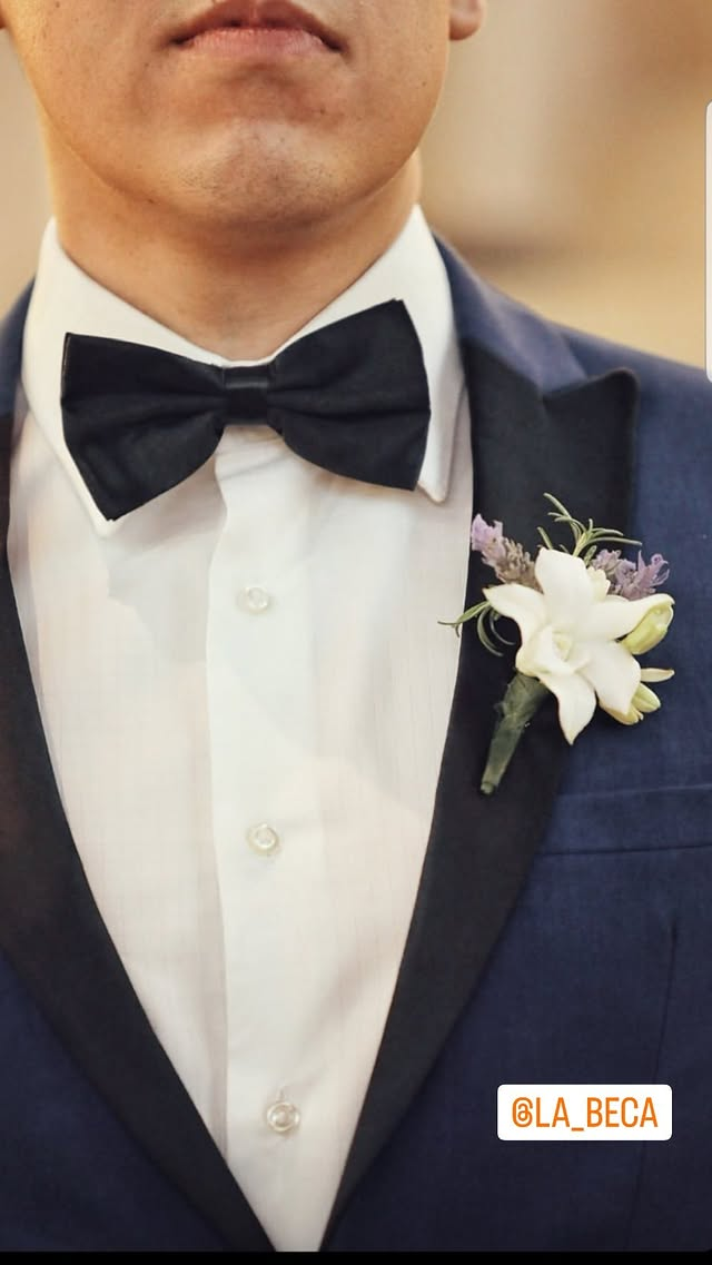 Detalhe de smoking azul-marinho com gravata borboleta e boutonnière