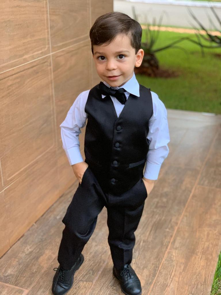 Criança usando smoking infantil preto com colete e gravata borboleta